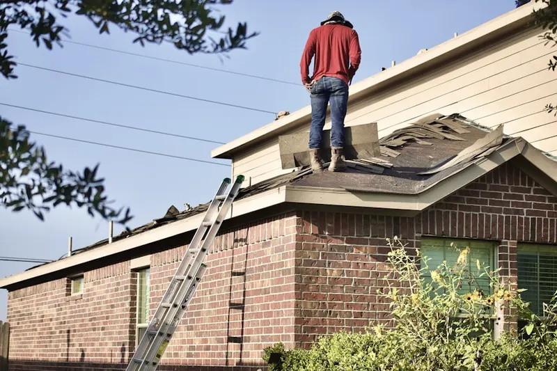 Professional roofer working on a residential roof in Pleasant Run Farm